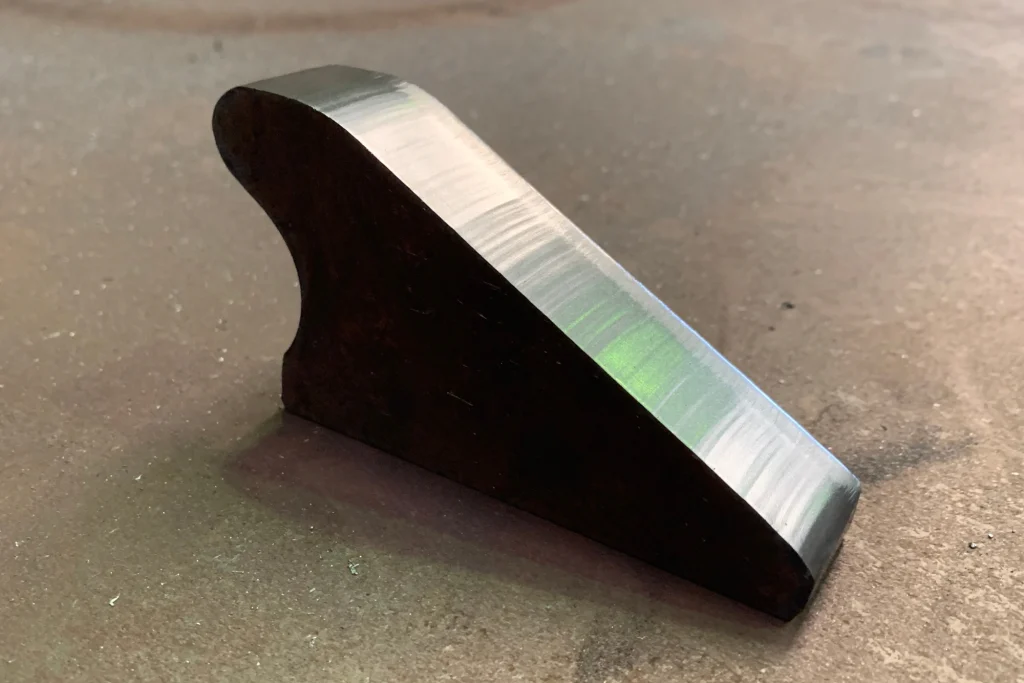 Pieza triangular de acero cortada por plasma con el canto limpio y sin escoria