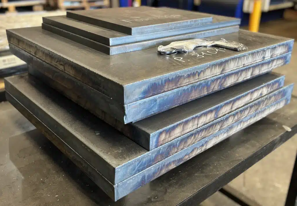 Placas gruesas de acero cortadas por oxicorte, apiladas mostrando el canto de corte